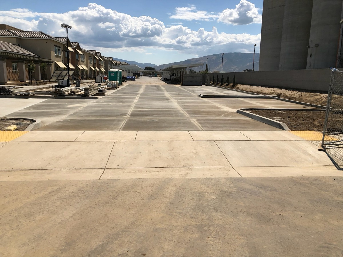 Wide freshly finished concrete driveway with control joints