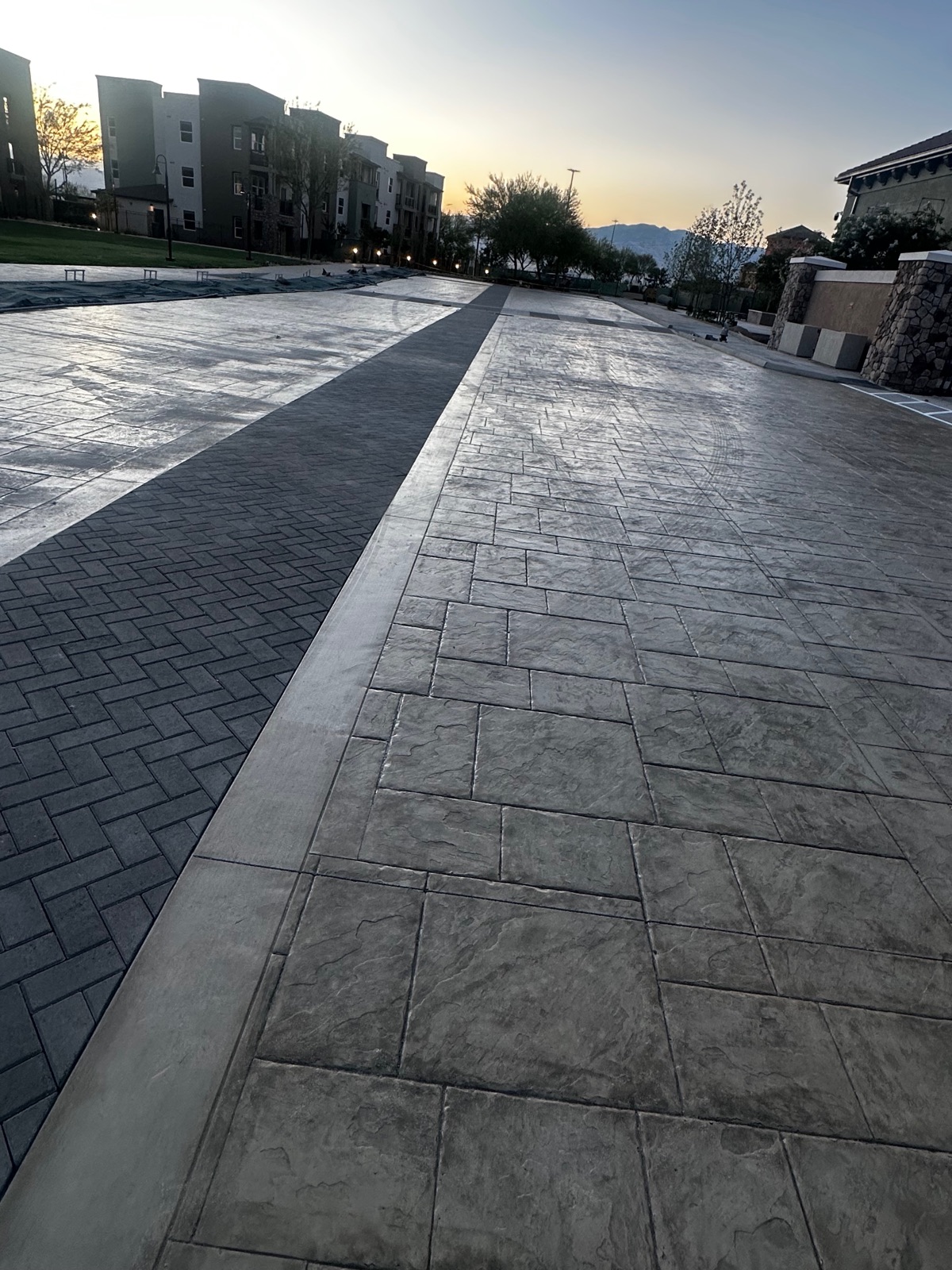 Decorative stamped-concrete plaza and walkways at dusk by Villalobos Concrete